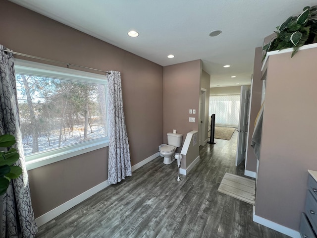 bathroom featuring toilet, baseboards, wood finished floors, and recessed lighting