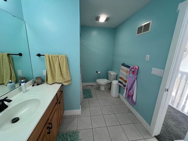 bathroom with visible vents, toilet, vanity, baseboards, and tile patterned floors