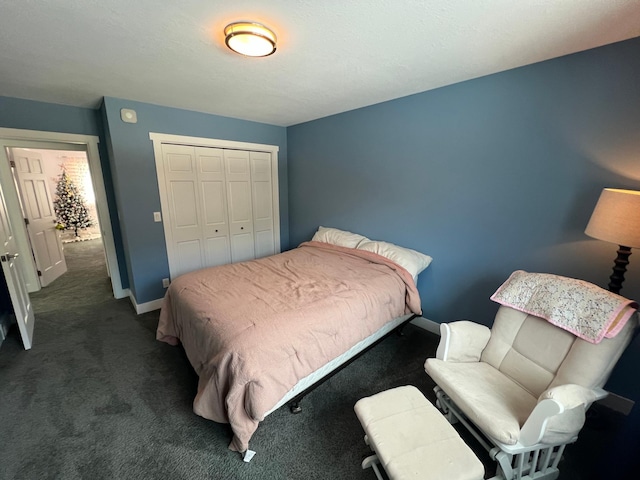 bedroom featuring baseboards, dark carpet, and a closet