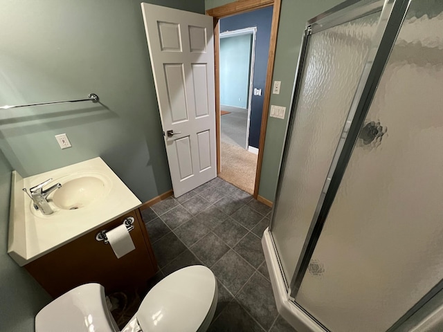 full bathroom with toilet, a stall shower, vanity, and baseboards