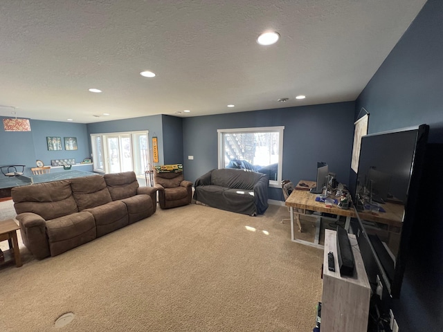 carpeted living area featuring a textured ceiling and recessed lighting