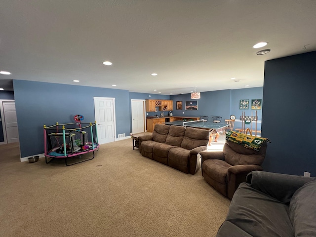 living area with light carpet, baseboards, visible vents, and recessed lighting