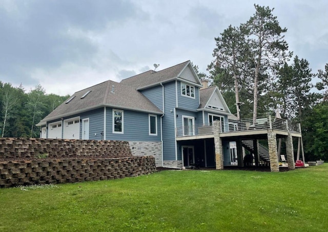 rear view of property with a garage, a shingled roof, a lawn, stone siding, and stairway