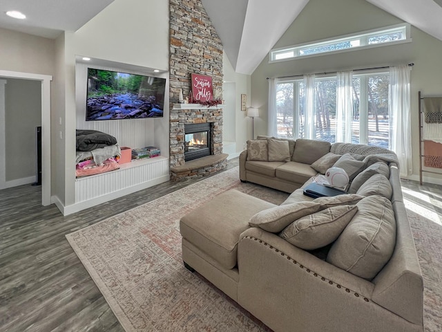 living room with high vaulted ceiling, a fireplace, and dark wood finished floors