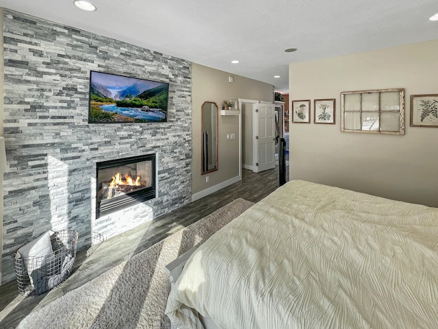 bedroom featuring a fireplace, baseboards, wood finished floors, and recessed lighting