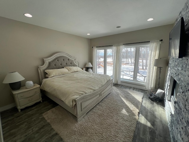 bedroom featuring a fireplace, dark wood-type flooring, and recessed lighting