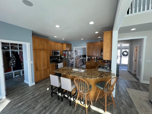 13849 Leaf River Rd, Wadena, MN 56482 - kitchen featuring appliances with stainless steel finishes, a peninsula, dark wood-style floors, brown cabinets, and recessed lighting