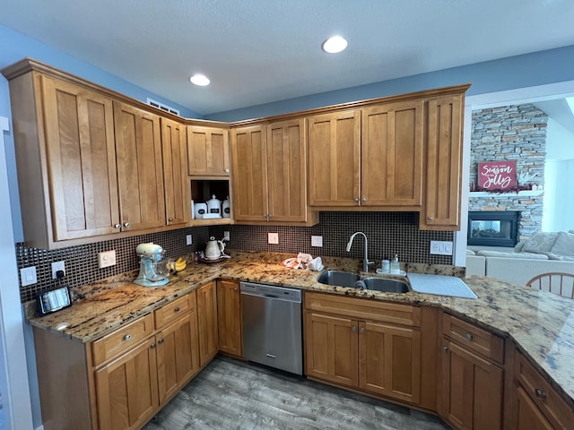 13849 Leaf River Rd, Wadena, MN 56482 - kitchen featuring stainless steel dishwasher, a sink, light wood-style floors, decorative backsplash, and light stone counters