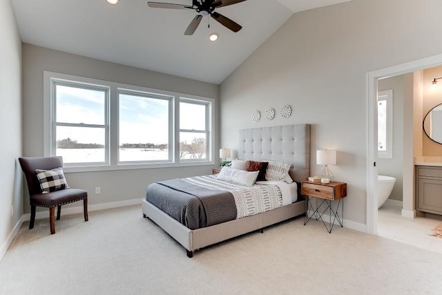 bedroom featuring high vaulted ceiling, baseboards, connected bathroom, and light colored carpet