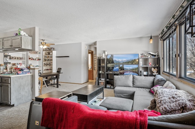 living room featuring light carpet, ceiling fan, baseboards, and a textured ceiling