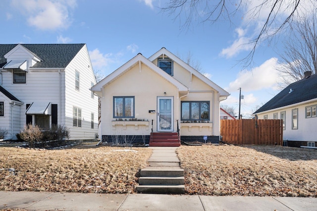 bungalow-style home featuring fence