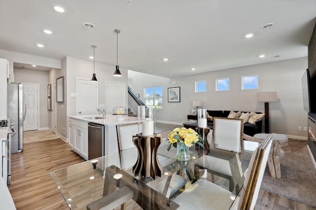 dining area featuring baseboards, light wood-type flooring, and recessed lighting