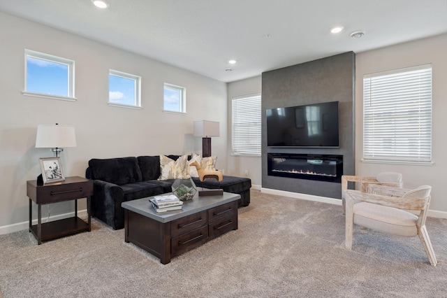 living area featuring recessed lighting, light carpet, a fireplace, and baseboards