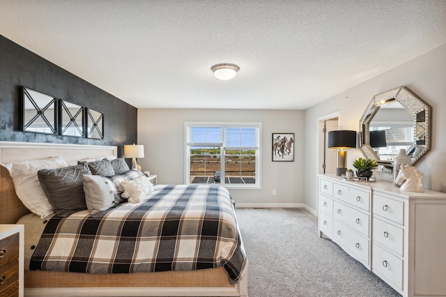 bedroom featuring light carpet, a textured ceiling, and baseboards