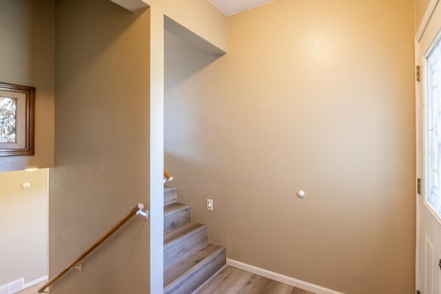 stairs featuring wood finished floors, visible vents, and baseboards