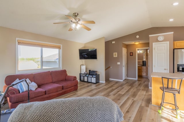 living area with lofted ceiling, ceiling fan, baseboards, and light wood-style floors