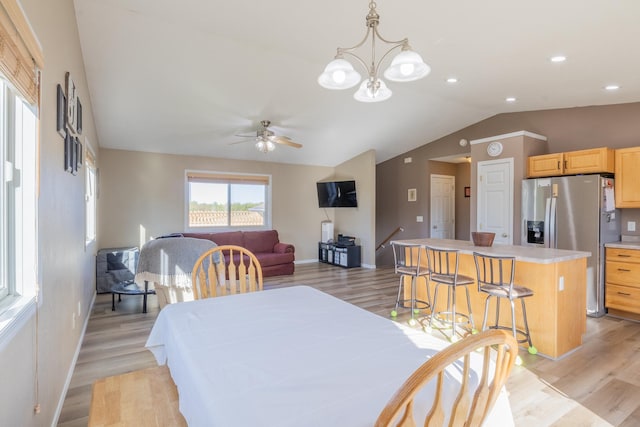 dining room featuring light wood-style flooring, baseboards, and vaulted ceiling