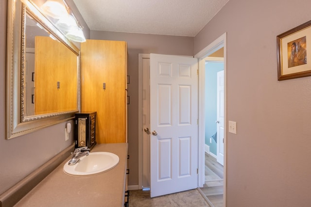 bathroom featuring a textured ceiling and vanity