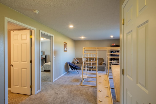 corridor featuring recessed lighting, light carpet, a textured ceiling, and baseboards