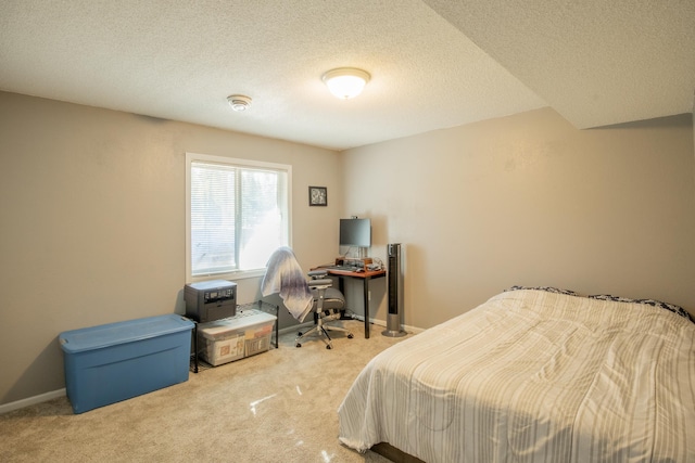 bedroom with light colored carpet, a textured ceiling, and baseboards