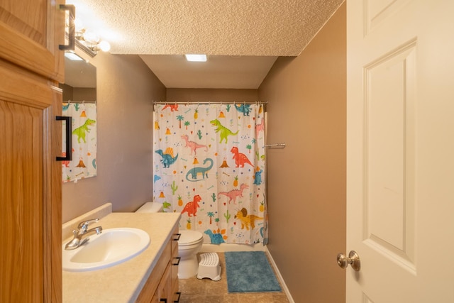 bathroom featuring baseboards, toilet, vanity, and a textured ceiling