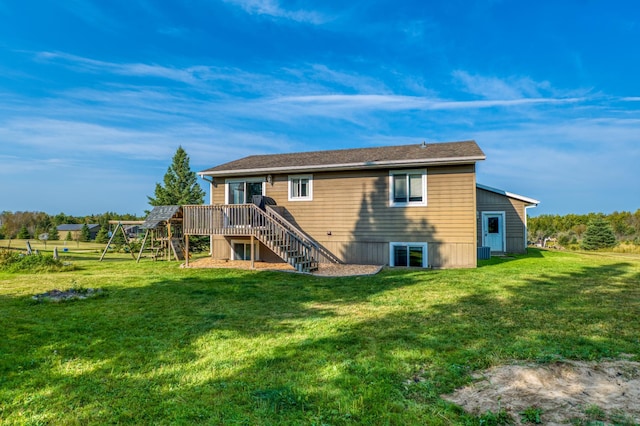 back of property with a lawn, a wooden deck, and stairs