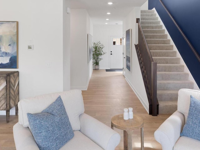 living room featuring baseboards, stairway, wood finished floors, and recessed lighting