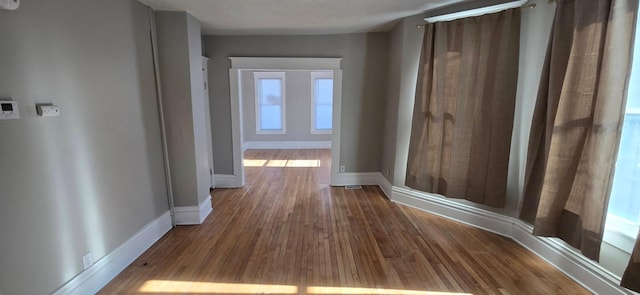 hall featuring baseboards and wood finished floors