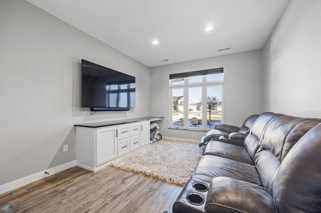 living area with visible vents, baseboards, wood finished floors, and recessed lighting