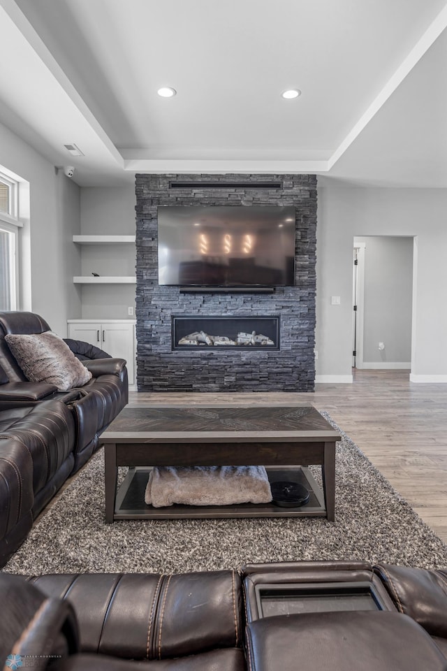 living room with visible vents, baseboards, wood finished floors, and recessed lighting