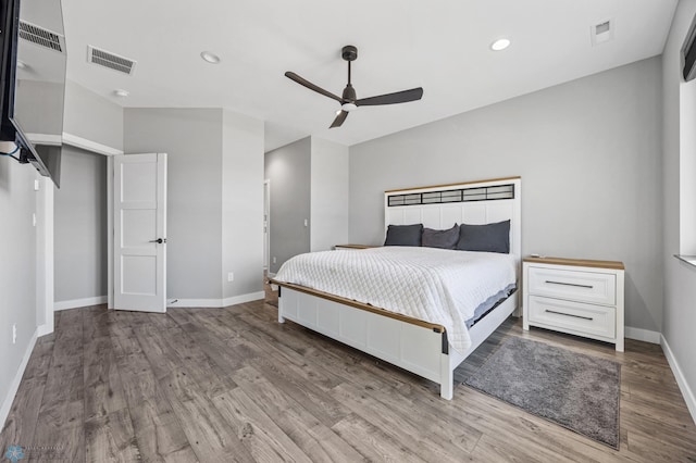 bedroom with recessed lighting, visible vents, baseboards, and wood finished floors