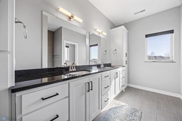 bathroom with visible vents, a sink, baseboards, and double vanity