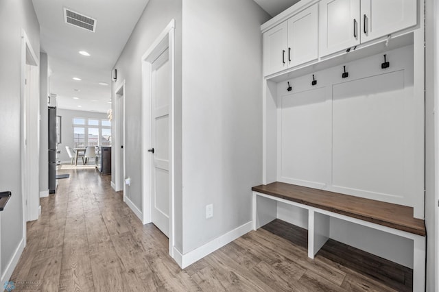 mudroom with light wood-style floors, baseboards, visible vents, and recessed lighting