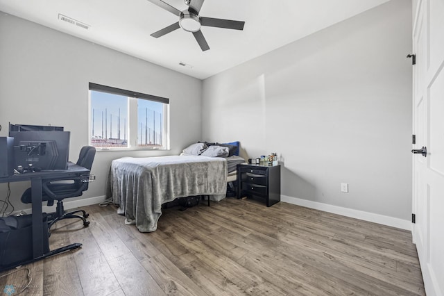 bedroom featuring wood finished floors, visible vents, and baseboards