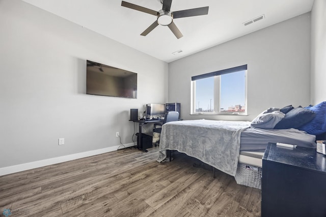 bedroom with a ceiling fan, baseboards, visible vents, and wood finished floors