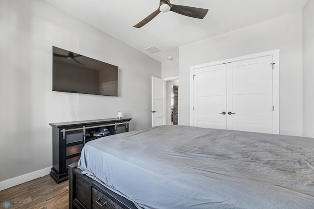 bedroom with baseboards, visible vents, ceiling fan, dark wood-type flooring, and a closet