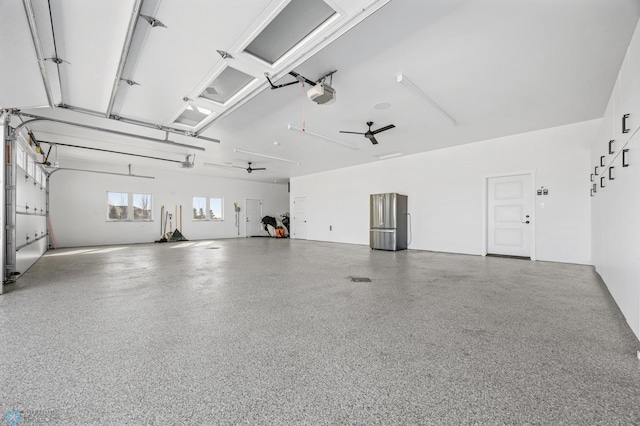 garage featuring a garage door opener, freestanding refrigerator, and ceiling fan