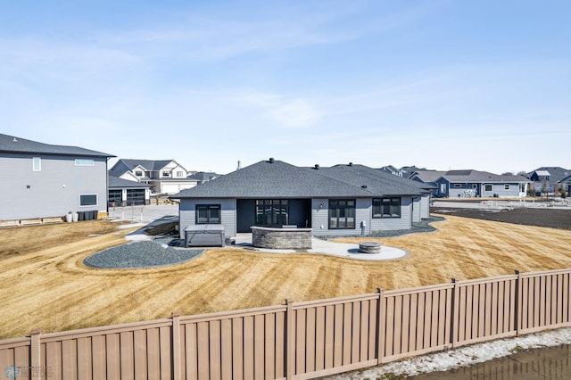 view of front of property featuring an outdoor fire pit, fence, a patio, and roof with shingles