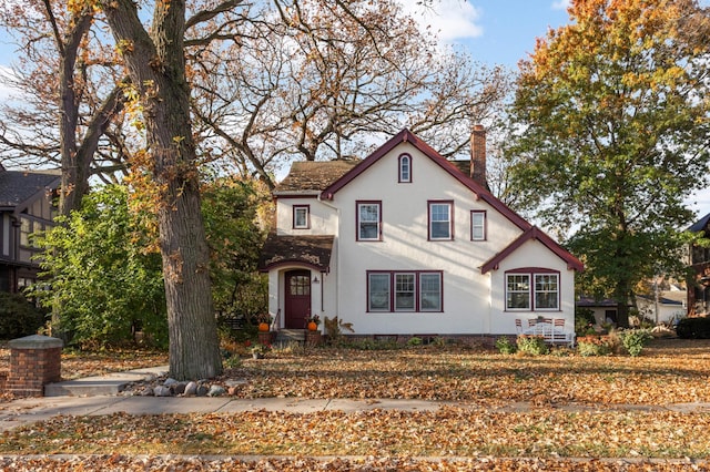 view of front of home with a chimney and stucco siding