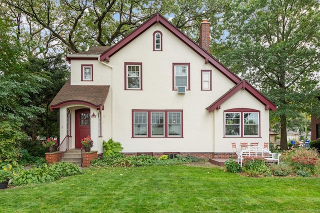 view of front of home featuring a front yard, a chimney, and stucco siding