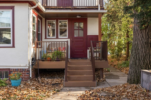 doorway to property featuring a balcony and stucco siding