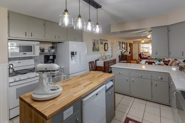 kitchen featuring white appliances, gray cabinets, and wood counters