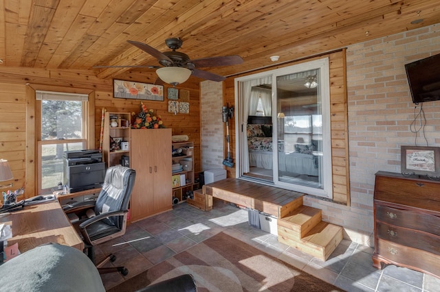 office area featuring a ceiling fan, wooden ceiling, wooden walls, and brick wall