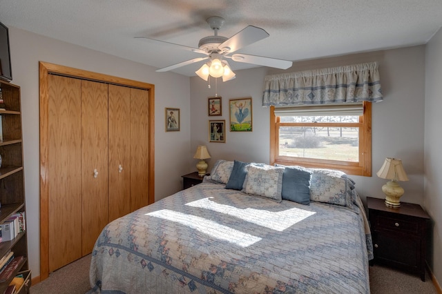 carpeted bedroom with a textured ceiling, a ceiling fan, and a closet