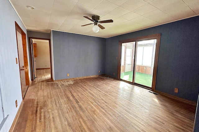 unfurnished room with ceiling fan, baseboards, visible vents, and light wood-style floors