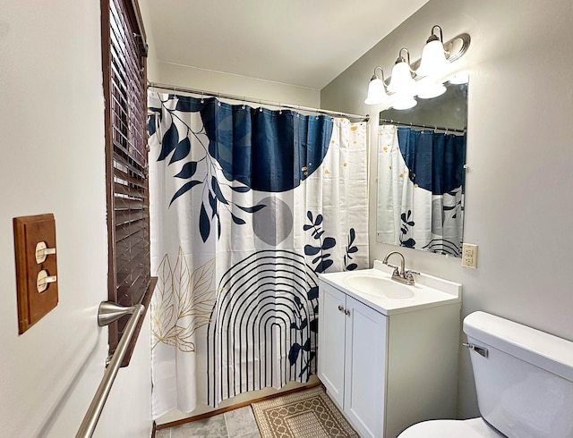 bathroom with curtained shower, vanity, and toilet