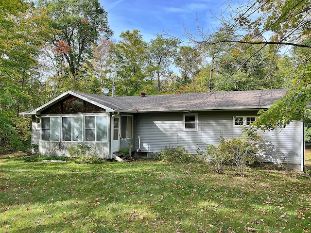 back of property with entry steps and a yard