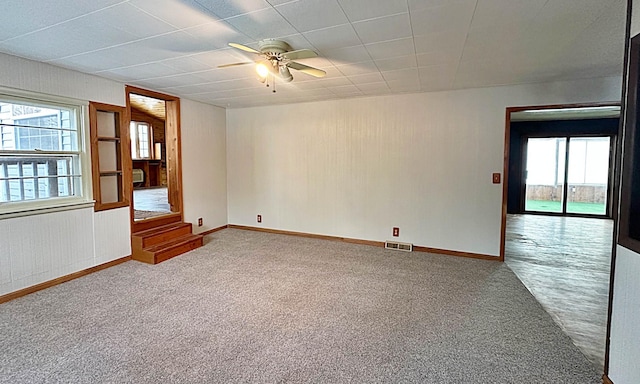 unfurnished room with a healthy amount of sunlight, visible vents, baseboards, and carpet flooring