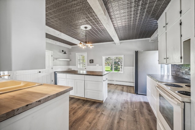 kitchen featuring electric range, wainscoting, a baseboard radiator, butcher block counters, and white cabinetry