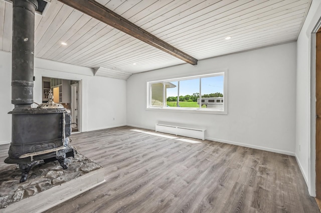 unfurnished living room with a wood stove, beamed ceiling, baseboard heating, and wood finished floors